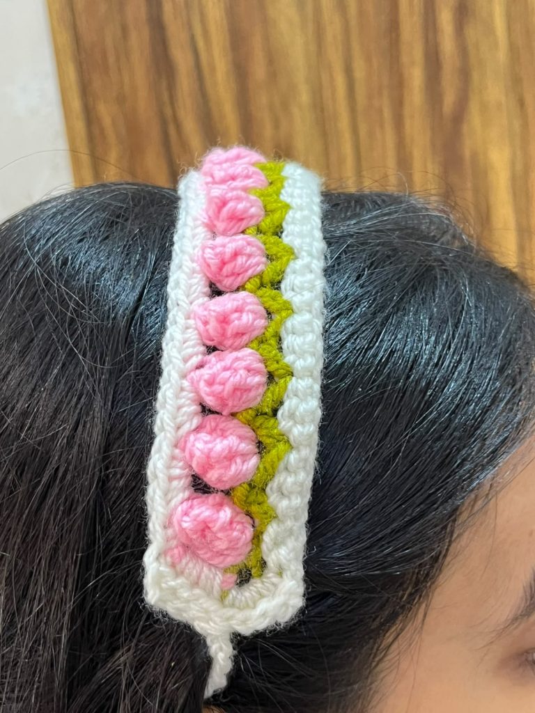 Pink handmade crochet floral headband with green leaf detailing